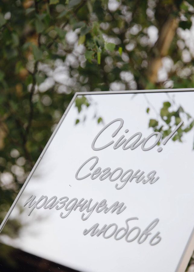 Зеркало с надписью «Ciao! Сегодня празднуем любовь» среди зелени